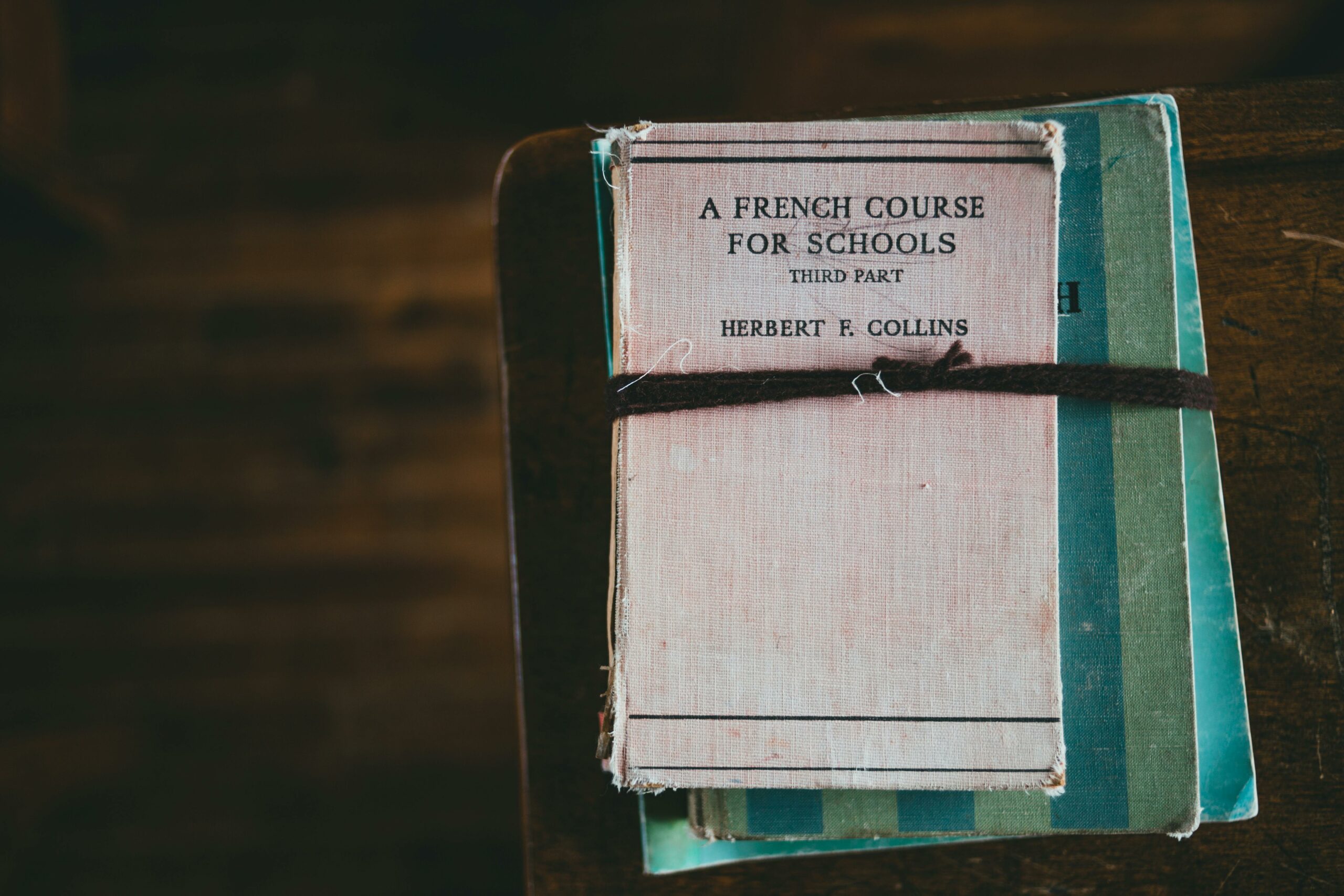 A vintage French language coursebook tied with string, evokes educational nostalgia.